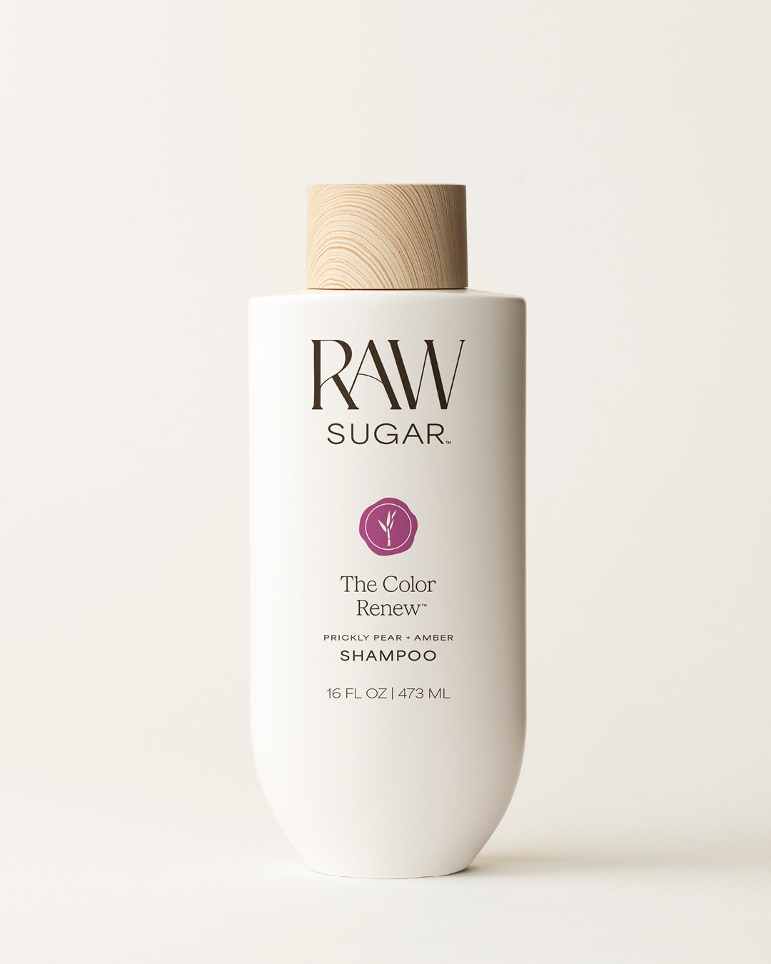Bottle of Raw Sugar Color Renew Shampoo on a cream background, designed to help color-treated hair with clean ingredients.
