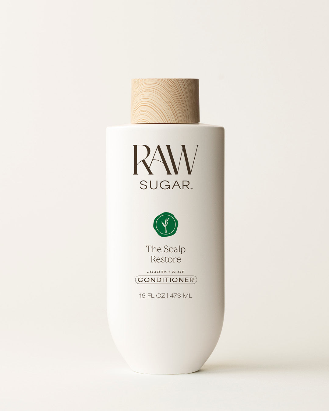 Bottle of Raw Sugar Scalp Restore Conditioner on a cream background, designed to help soothe scalp and hair with clean ingredients.