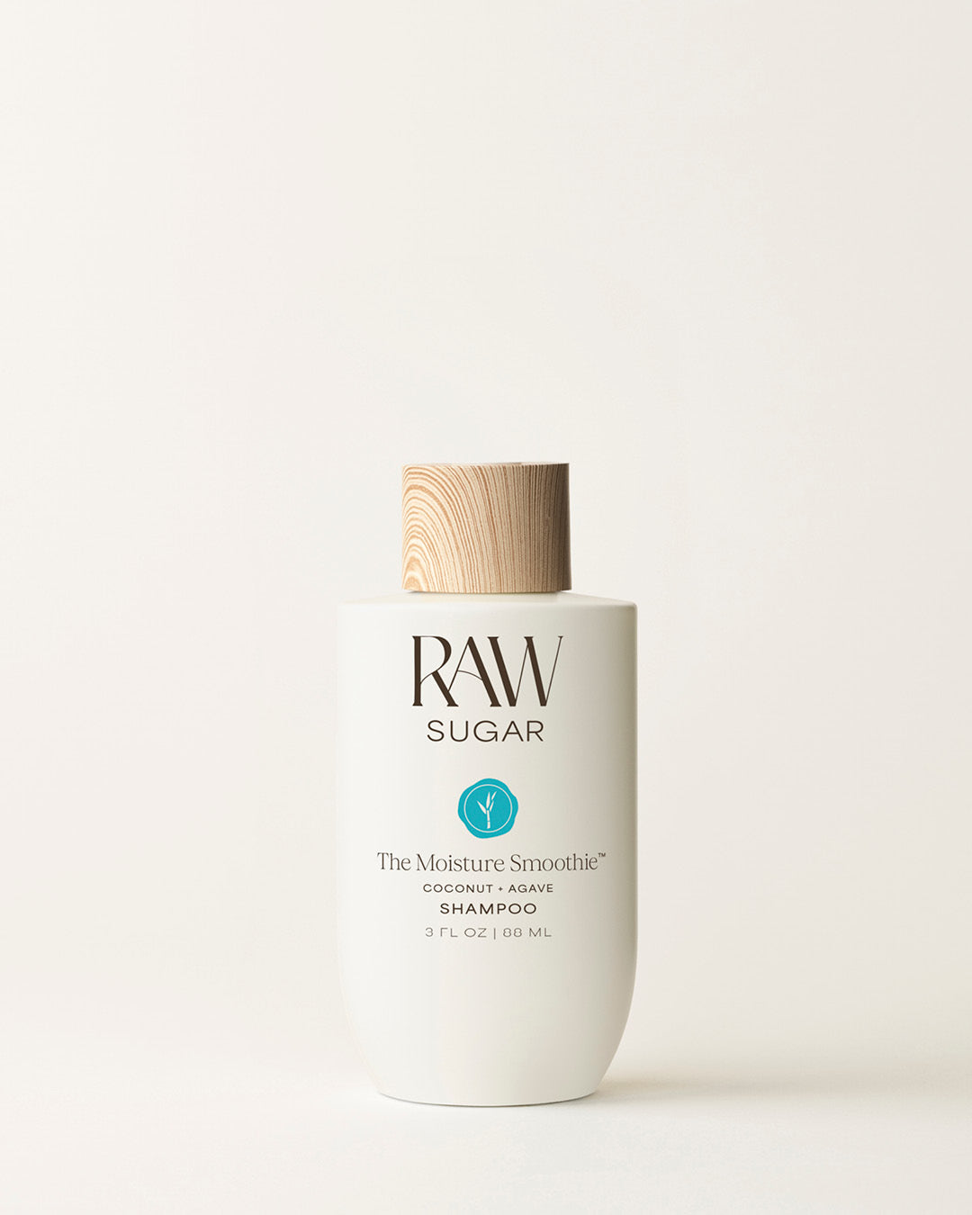 Travel Bottle of Raw Sugar Moisturizing Shampoo on a cream background, designed to help moisturize hair with clean ingredients.